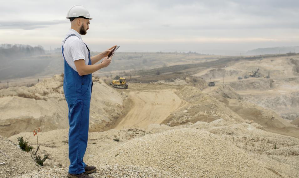 mine worker using a tablet on a open cast mine