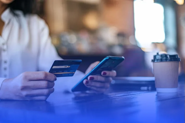 woman holding credit card and mobile