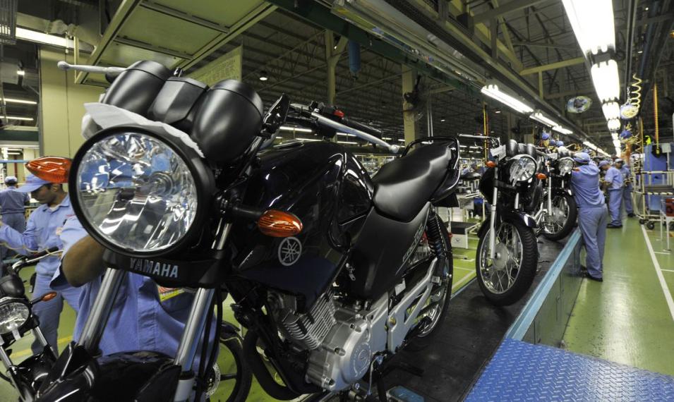 Yamaha motorcycle inside factory with factory workers in safety gear